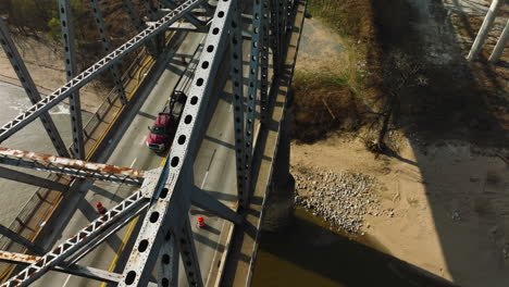 Aerial-shot-of-a-cyclist-crossing-the-Delta-Regional-River-Park-bridge-in-West-Memphis,-TN,-sunny-day