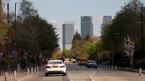 Skyline,-skyscrapers-in-Castlefield-area-of-central-Manchester,-UK,-static-street-view,-road-traffic-in-outskirts-of-city