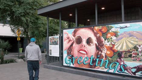 Greeting-mural-in-Palm-Springs,-California-with-man-walking-away-and-stable-video