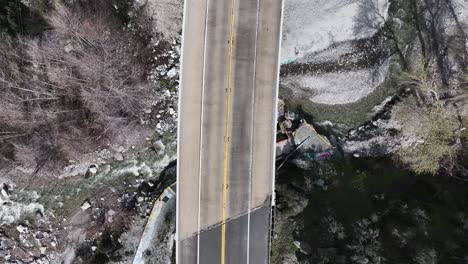 California-highway-38-to-forest-falls-top-down-showing-cars-passing-over-a-bridge-with-a-waterfall-underneath-60FPS