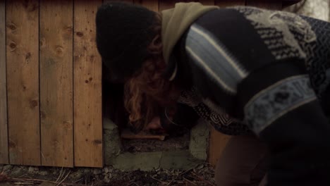 Man-Placing-Firewood-Under-His-DIY-Hot-Tub---Close-Up