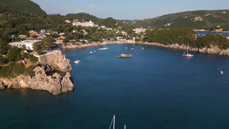 Drone-fly-above-sailboat-anchored-in-bay-of-Corfu-Greece-on-sunny-calm-afternoon