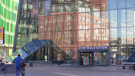 Gente-En-Bicicleta-Y-Caminando-Frente-A-La-Entrada-De-La-Estación-Central-De-Malmo.