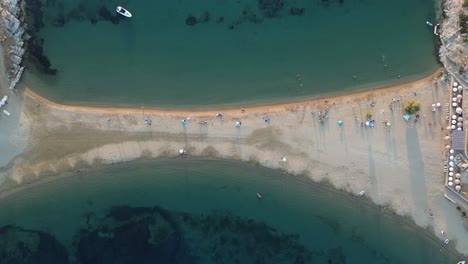 Land-bridge-connecting-two-islands-in-Greece,-Kythnos-Island--Aerial-top-down-view,-ascending