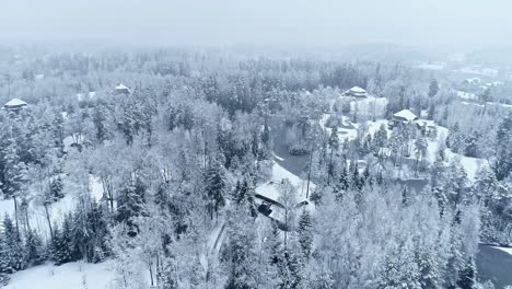 Fly-Back-Over-Snow-Covered-Rural-Village-During-Snowstorm-In-Wintertime