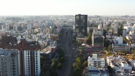 Vista-Aérea-De-Drones,-Muchos-Vehículos-Saliendo-Del-Puente-Y-Bajando-Por-La-Carretera-Y-Muchos-Edificios-Son-Visibles-Alrededor