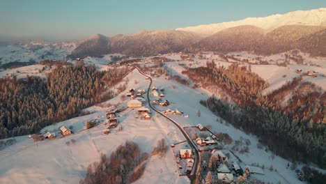 El-Amanecer-Brilla-Sobre-El-Pueblo-De-Pestera-Con-Techos-Cubiertos-De-Nieve,-Un-Paraíso-Invernal-Aéreo