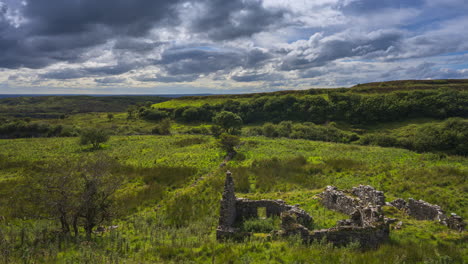 Timelapse-of-rural-nature-landscape-with-ruins-of-old-abandoned-stone-house-in-the-foreground-during-sunny-cloudy-day-viewed-from-Carrowkeel-in-county-Sligo-in-Ireland