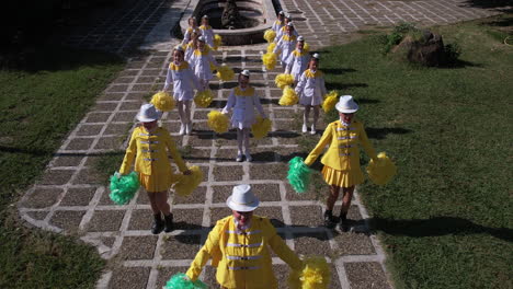 Luftaufnahme,-Majorette-Mädchen-In-Gelben-Und-Weißen-Uniformen-Treten-Auf-Einem-Festival-Auf