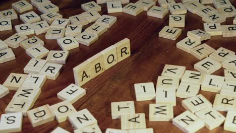 La-Mano-Derecha-Coloca-Fichas-De-Letras-De-Scrabble-En-El-Borde-Para-Formar-La-Palabra-Aborto.