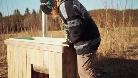 Man-Placing-Woods-For-His-Homemade-Hot-Tub---Close-Up