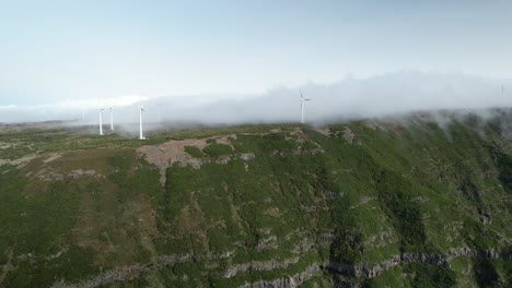 Wolken-über-üppigem-Grün-Madeiras-Berggipfel-Bedecken-Rotierende-Windräder