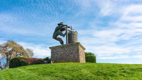 Das-Napa-Valley,-Die-Traubenpresse-Skulptur-Im-Zeitraffer-Mit-Zurückziehenden-Wolken-Und-In-Einer-Lebendigen-Umgebung-Mit-Blauem-Himmel-Und-Grünem-Gras