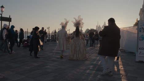 Carnival-Duo-in-Golden-Sunset-Light,-walking-through-Venice