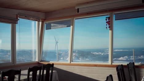 Blick-Auf-Eine-Windmühle-Durch-Das-Glasfenster-Von-Møllestua-Während-Der-Wintersaison-In-Bessaker,-Provinz-Trondelag,-Norwegen-–-Handaufnahme