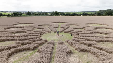 Persona-Que-Lleva-Una-Máscara-Alienígena-En-La-Vista-Aérea-Del-Círculo-De-Cultivos-De-Andover-Que-Establece-La-Revelación-Del-Patrón-Molecular-En-El-Campo-De-Trigo-Dorado