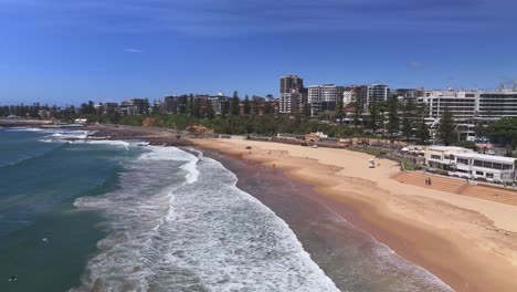 Luftaufnahme-über-North-Wollongong-Beach-Mit-Schwimmbädern-Und-Wollongong-Harbour-Dahinter