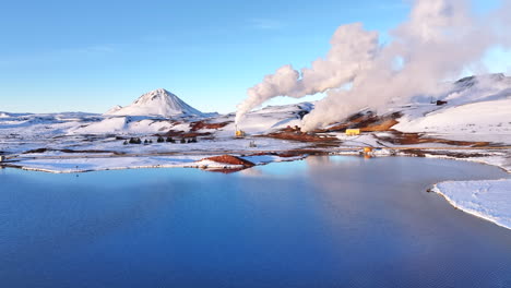 Myvatn-geothermal-area-with-steam-vents-on-snowy-landscape,-golden-light,-aerial-view