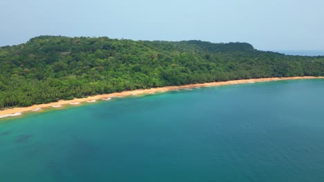 Flying-over-the-sea-towards-Praia-Grande,-a-beach-knew-for-having-a-large-expanse-of-sand-and-being-a-place-where-turtles-lay-their-eggs,making-that-place-a-favorite-nest,Prince-Island,Africa