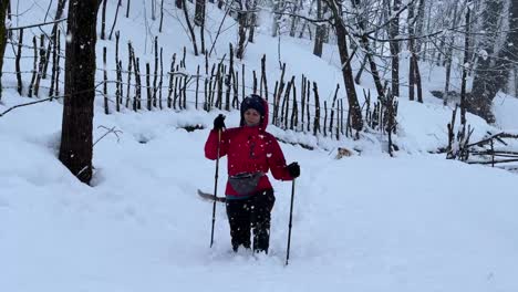 Caminar-Duro-En-Fuertes-Nevadas-En-Invierno-En-El-Bosque-De-Hircanian-Paisaje-Invernal-Nevadas-En-Una-Naturaleza-Maravillosa-Pueblo-Rural-Campo-Bastón-De-Trekking-Chaqueta-De-Color-Rojo-Y-Pantalón-Negro-Persona-Caminando-Solo-Irán