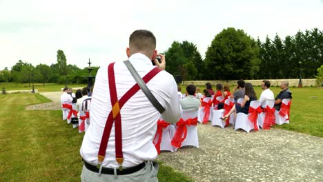 A-photographer-takes-wedding-photos-during-the-secular-ceremony,-red-and-white-dresscode