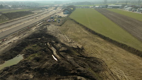 Aerial-view-of-a-highway-under-construction-with-surrounding-fields