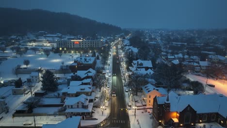 Snowy-town-at-dawn-with-Christmas-decorations-lining-main-street-in-Ephrata,-Pennsylvania