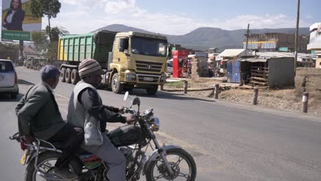 Dos-Hombres-En-Bicicleta-Intentando-Cruzar-La-Calle-Con-Mucho-Tráfico-De-Coches-Y-Camiones.