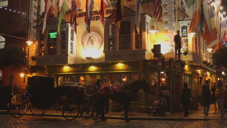 Profile-view-of-horse-cart-in-front-of-the-famous-The-Oliver-Pub-in-Dublin,-Ireland