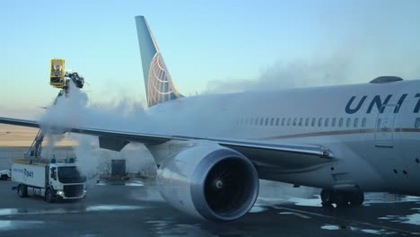 Personal-De-Tierra-Rociando-Líquido-Descongelante-En-El-Ala-De-Un-Avión-De-Pasajeros-En-La-Puerta-De-Embarque