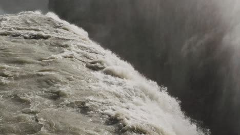 Closeup-Gullfoss-iceland,-famous-golden-waterfall-flowing-between-rock-hvita-canyon,-water-fog-steam-rising