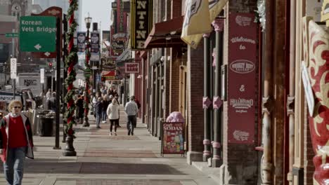 Tourists-on-Broadway-Street-in-Nashville,-Tennessee-during-the-day-with-medium-shot-video-pan-right-to-left