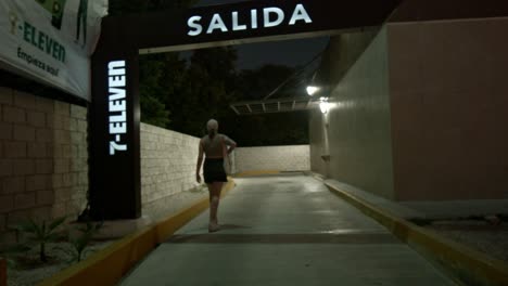 Caucasian-tourist-walks-into-a-7-eleven-drive-through-exit-lane-in-mexico