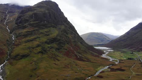 Vista-Aérea-Del-Espectacular-Paisaje-De-Glencoe-En-Escocia-Con-El-Río-Coe-Fluyendo-En-El-Medio