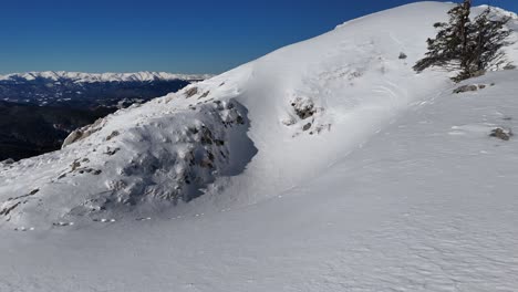 Pendiente-Cubierta-De-Nieve-Con-Huellas-En-Las-Montañas-De-Bucegi,-Vista-Hacia-Iezer-papusa-Y-Piatra-Craiului