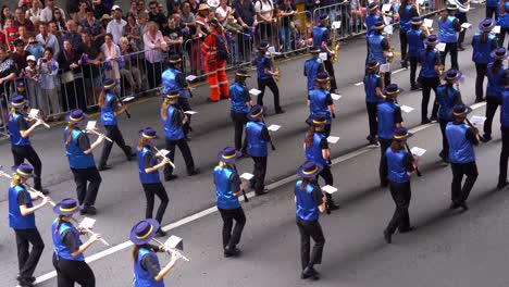 Queensland-students-from-Mackay-North-State-High-School-Marching-Band-performing-and-walking-down-Adelaide-street-with-crowds-gathered-alongside,-honouring-the-memory-of-those-who-served