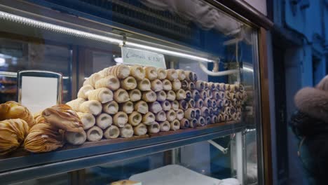 Neatly-stacked-cannoli-in-a-display-case,-Venice