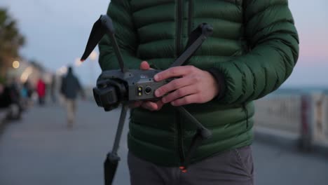 Man-Preparing-To-Launch-Camera-Drone-In-Varazze,-Italy