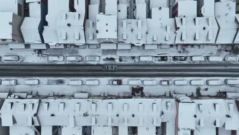 Conducir-Un-Coche-Por-Una-Carretera-Nevada-En-Una-Zona-De-Viviendas-Cubierta-De-Nieve-En-EE.UU.