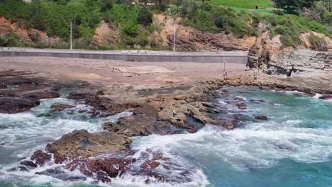 Un-Pescador-Listo-Para-Comenzar-Su-Sesión-De-Pesca-Desde-Las-Rocas-Mojadas-En-La-Playa-De-Wollongong.