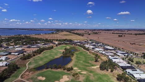 Aerial-across-golf-course-and-billabong-with-new-houses-and-Lake-Mulwala-nearby-in-Yarrawonga-Victoria-Australia