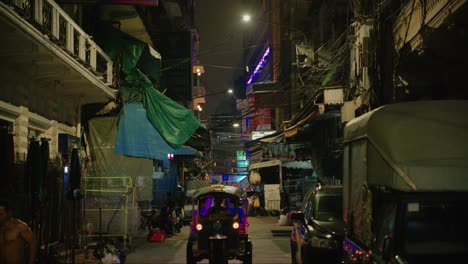 Paisaje-Urbano-Nocturno-De-Bangkok-Con-Tiendas-Locales-Y-Tuk-tuk