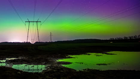 Timelapse-shot-of-Northern-lights-Polar-Aurora-Borealis-dancing-over-an-electric-pole-surrounded-by-water-puddle-at-night-time