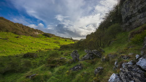 Timelapse-of-rural-nature-farmland-with-line-of-trees-and-rocks-in-the-foreground-located-in-stoneground-field-during-cloudy-sunny-day-viewed-from-Carrowkeel-in-county-Sligo-in-Ireland