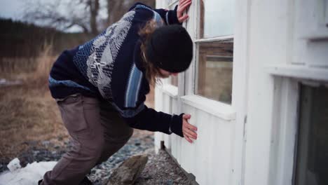 The-Man-is-Placing-a-Wooden-Plank-Inside-the-Storage-House-and-then-Securing-the-Door-to-Prevent-it-From-Opening,-All-in-Preparation-For-Use-in-the-DIY-Hot-Tub---Close-Up