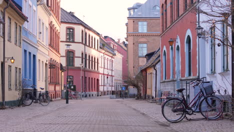 Empty-cobbled-street-in-Gamla-staden-with-parked-bicycles-and-colorful-buildings