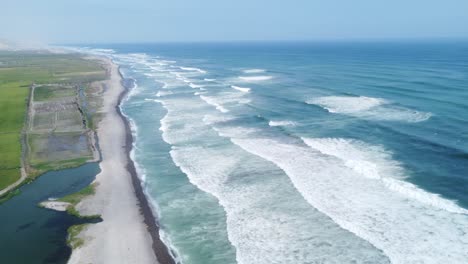 Strand-Und-Natur-Zusammen-In-Einem-Wunderschönen-Blauen-Himmel-Mit-Den-Wellen,-Die-Den-Grauen-Sand-Küssen