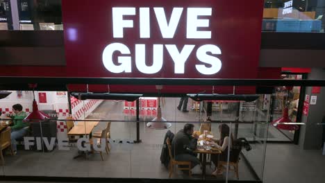 Customers-eat-at-the-American-fast-food-casual-restaurant-chain-Five-Guys-in-Madrid,-Spain