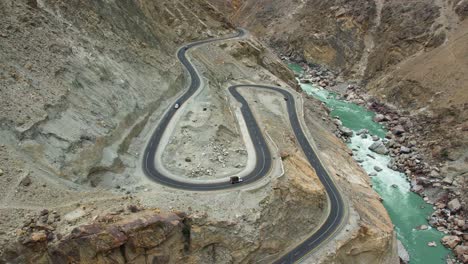 Aerial-view-of-Pakistani-vehicles-driving-through-curvy-roads-in-Skardu,-Pakistan