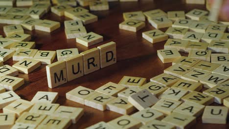 Scrabble-Azulejos-Colocados-En-El-Borde-Forman-La-Palabra-Asesinato-En-Letras-Individuales